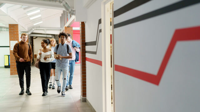 Group of diverse high school students walking through the hall