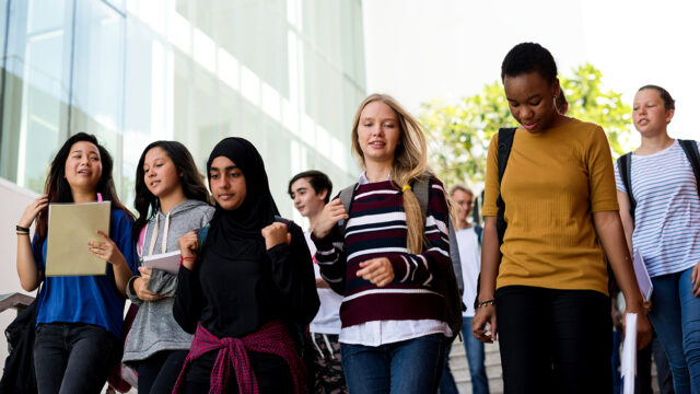 Diverse group of students walking in school