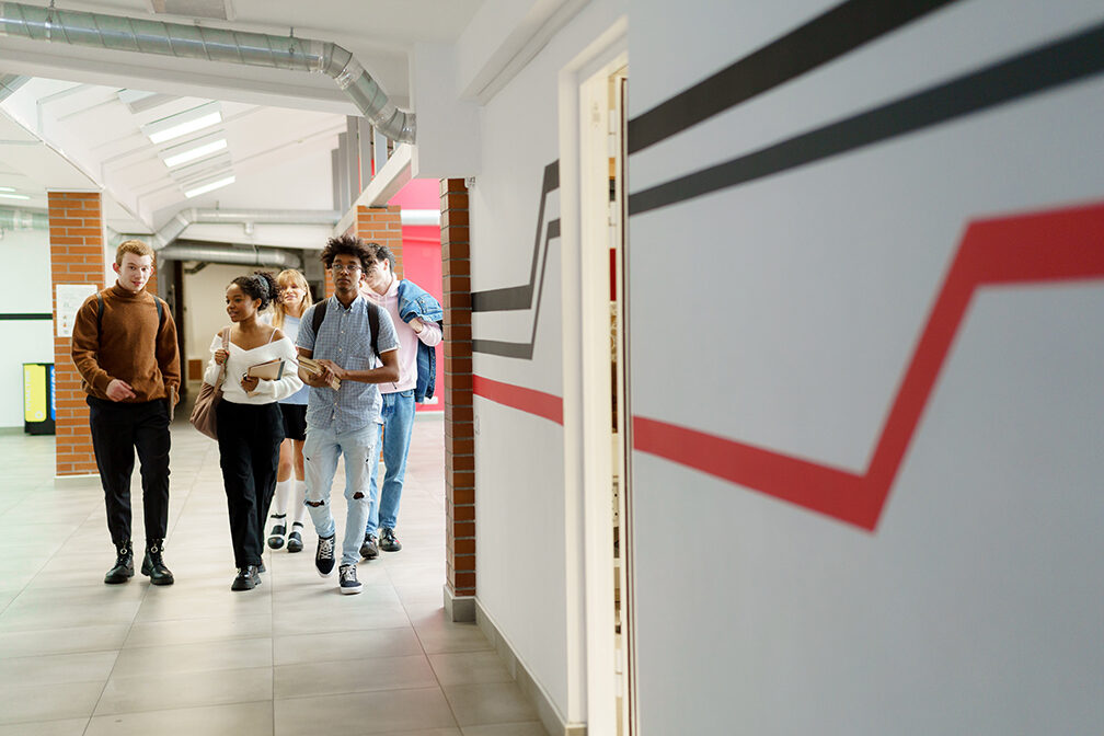 Group of diverse high school students walking through the hall