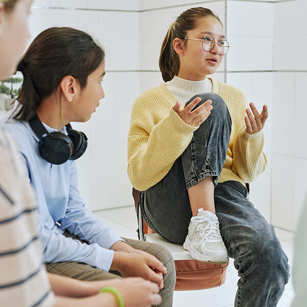 Portrait of teenage girl sharing feelings in support group circle for children